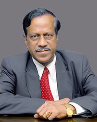 Mr. Ponnavaiko Bandara, Registrar (Evaluation) of Vennikulam University, seated at a desk, reviewing documents.